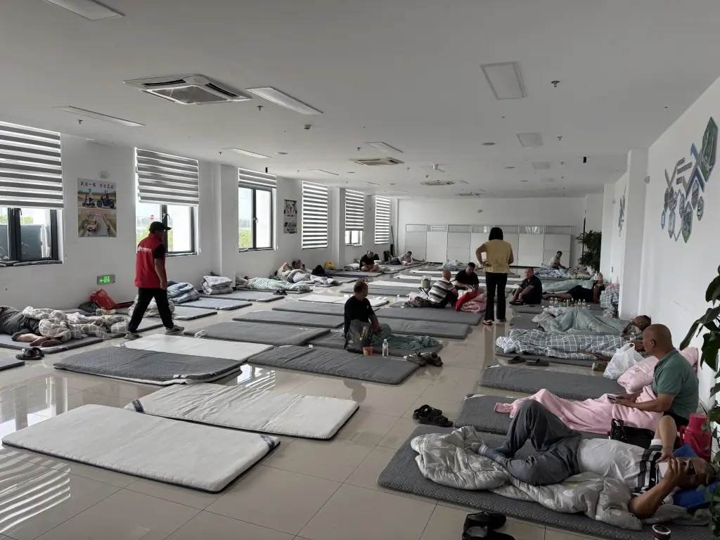 挨个敲开大货车的门，他在台风来临前化身志愿者带同行“回家”
